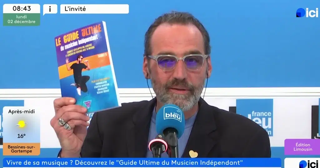 Animateur télé tenant présentant le Guide Ultime du musicien indépendant à la télé