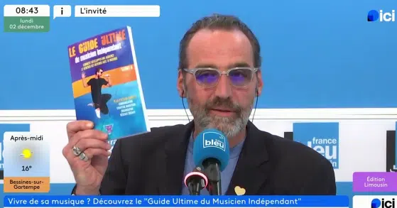 Animateur télé tenant présentant le Guide Ultime du musicien indépendant à la télé